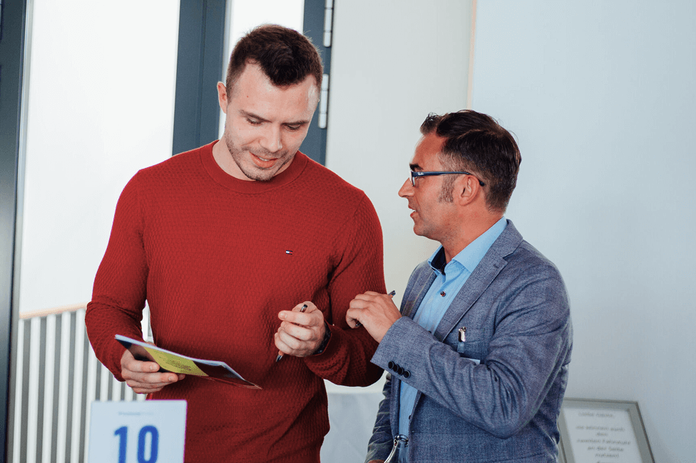 Benjamin Friedrich, BU-Versicherungsexperte, steht neben einer Person und erklärt etwas